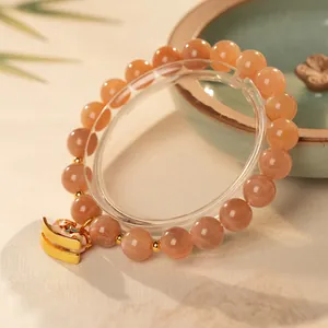 Natural sunstone beaded bracelet with golden enamel horse pendant in elegant warm orange