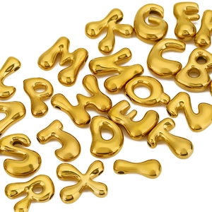 Vue macro des perles lettres bulles en acier inoxydable doré pour création de bijoux
