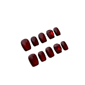 Faux ongles faits main œil de chat bordeaux avec strass rouges et forme carrée-arrondie