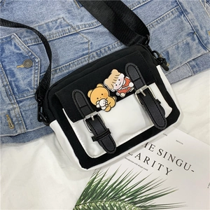Detail view of canvas crossbody bag with decorative pins and adjustable black strap