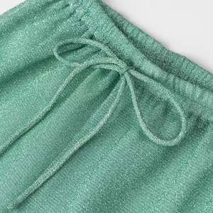 Vue macro détaillée du tissu vert scintillant et de la taille élastiquée avec cordon