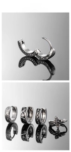 Macro display of vintage steel earrings with cross charms and textured metal patterns