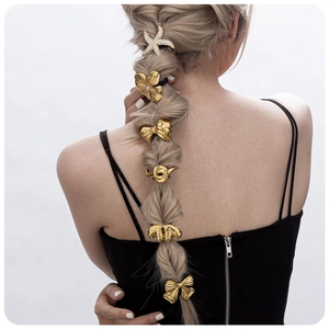 Golden alloy hair charms set featuring starfish and floral designs on a long braid