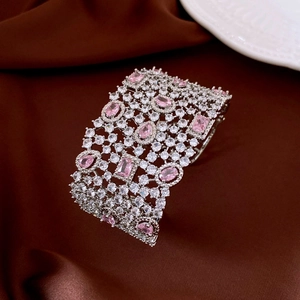 Detailed close-up of wide silver bangle featuring pink crystals and pavé zircon stones