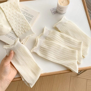 Calze color crema in maglia traforata con eleganti bordi a volant e trama a coste