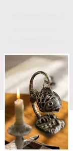 Detail of vintage cast iron fish candle holder with hollow mesh design for warm lighting