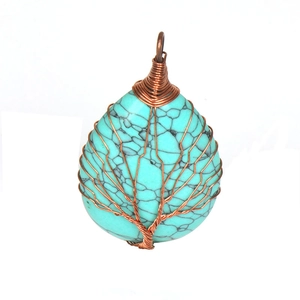 Close-up of handmade tree of life wire-wrapped necklace with teardrop turquoise stone