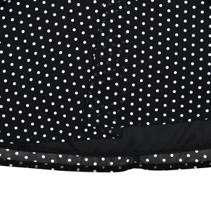 Detail shot of black and white polka dot chiffon dress hem showing neat stitching and lining