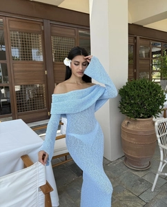 Detail of light blue off-shoulder knitted dress showing textured weave and long sleeves