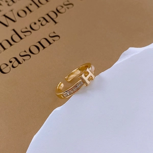 Detail shot of a gold-plated H-letter ring featuring sparkling cubic zirconia stones