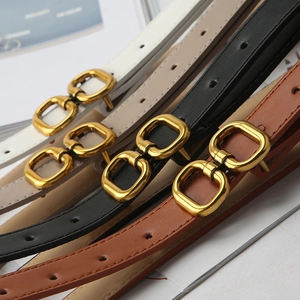 Close-up of four thin leather belts in white, beige, black, and brown with gold double rings