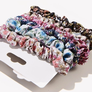 6-piece set of floral fabric scrunchies in blue, pink, and red on white display card