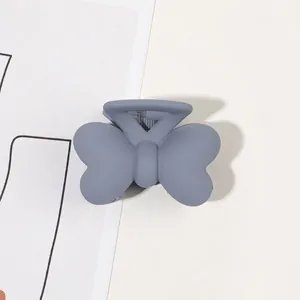 Close-up of matte butterfly claw clip in dusty blue with durable metal spring detail