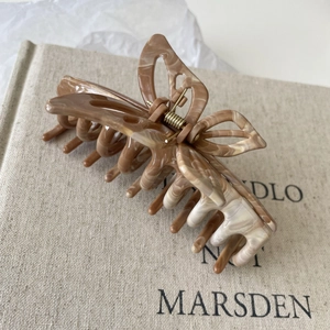 Detailed macro view of the brown marble texture on the acetic acid butterfly hair clip