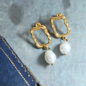 Irregular geometric 18K gold plated earrings with baroque pearls on textured background