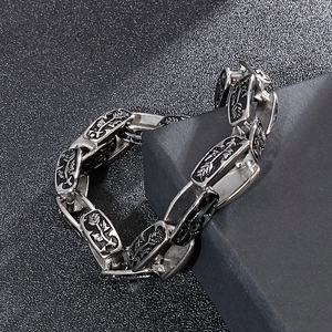 Macro detail of vintage punk steel bracelet with embossed rose and arrow patterns