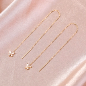 Macro shot of rose gold threader earrings featuring sparkling cubic zirconia butterfly charms