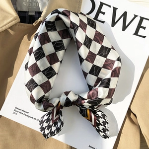 Detail of silk scarf with checkered and houndstooth patterns on a stylish book