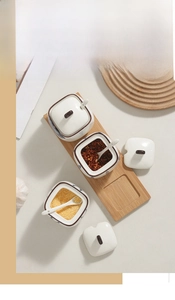 Detailed top view of ceramic spice jars with wooden tray and blue ink floral patterns