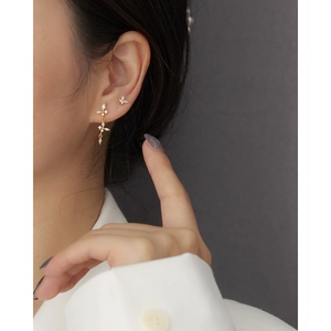 Gros plan de boucles d'oreilles papillon dorées avec cristaux portées par un mannequin