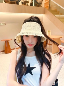 Dettaglio del cappello da sole in maglia bianco crema con elegante trama traforata