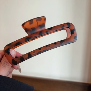 Macro view of a large rectangular hair claw clip with classic brown tortoiseshell pattern