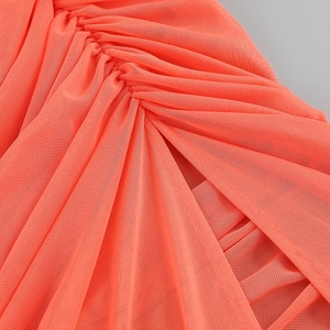 Detailed macro view of the bright orange mesh fabric with elegant pleated design
