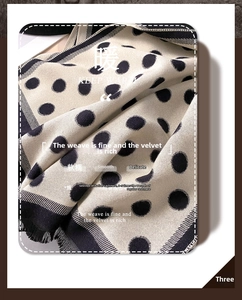 Detail of soft cream and black polka dot cashmere feel scarf with fringe