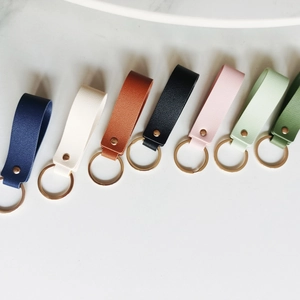 Detailed view of various colorful PU leather keychains with golden metal rings