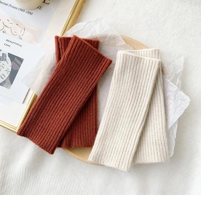 Close-up of ribbed knit texture on fingerless arm warmers in brown and beige tones
