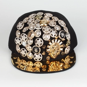 Detail of hip-hop snapback cap featuring metal studs and sun god medallions