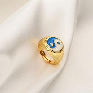 Detail eines verstellbaren Goldrings mit blau-weißem Emaille-Herz-Yin-Yang-Design