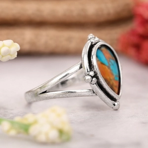 Détail de la bague vintage en argent avec pierre en forme de poire bleue et orange