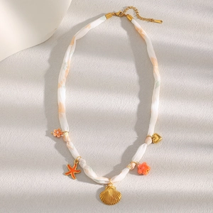 Detail of 18K gold plated stainless steel necklace with sea shell and starfish charms