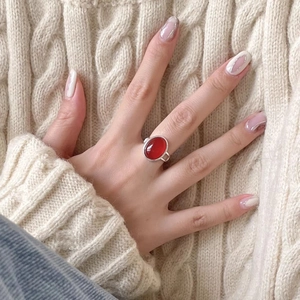 Anello minimalista in argento 925 con agata rossa ovale indossato su una mano femminile