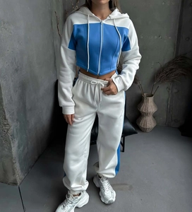 Dettaglio del set felpa con cappuccio corta bicolore blu e bianca e pantaloni jogger