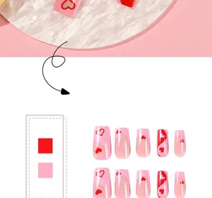 Detailed macro view of long trapezoid press-on nails with pink French tips and red hearts