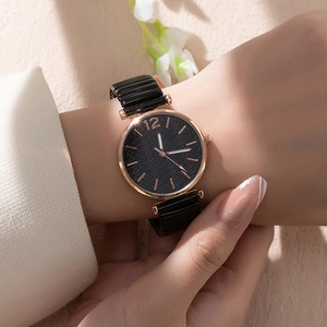 Dettaglio di un orologio al quarzo da donna con quadrante nero ondulato e cinturino elastico