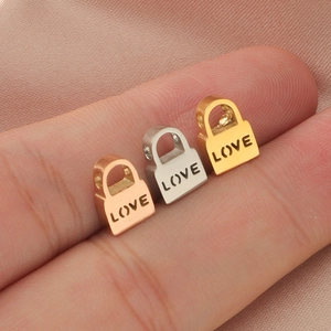 Macro shot of three small LOVE engraved lock charms in gold, silver and rose gold finishes