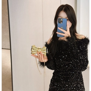 Glossy golden bow-shaped acrylic evening clutch bag with elegant metallic chain strap