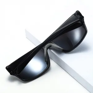 Polarized sports sunglasses with matte black frame and anti-slip nose pads on white stage