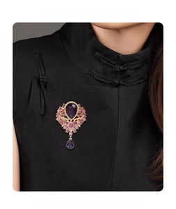 Detail view of vintage crystal brooch with purple teardrop gemstones on a black cheongsam