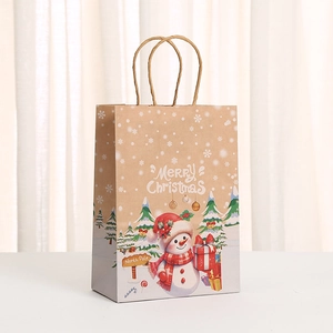 Close-up of Christmas paper gift bag with snowman print and Merry Christmas text
