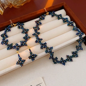 Detail of beaded jewelry set with blue necklace and earrings in a beige velvet gift box