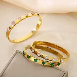Λεπτομέρεια από επιχρυσωμένα βραχιόλια 18k με ροζ, πράσινα και λευκά κρύσταλλα καρδιάς