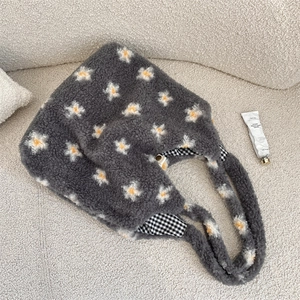 Detail view of daisy plush tote bag with grey fleece fabric and checkered inner lining