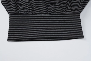 Detailed macro view showing the black and gray striped knit fabric and ribbed hem finish