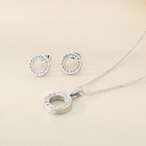 Dettaglio del set collana e orecchini tondi in acciaio argento con zirconi incastonati