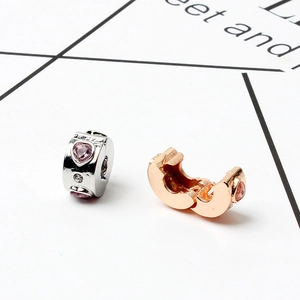 Détail de clips en forme de cœur or rose et argent avec cristaux roses et petits zircons