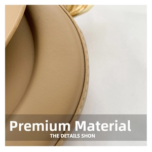 Detailed macro of khaki lychee grain leather with fine white stitching and gold hardware